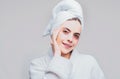 Young beautiful girl with a towel on head and a white robe girl cares for the skin using patches under her eyes Royalty Free Stock Photo