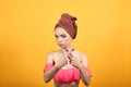 Young girl with towel on her head over isolated orange background shows emotions Royalty Free Stock Photo