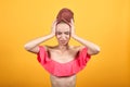 Young girl with towel on her head over isolated orange background shows emotions Royalty Free Stock Photo