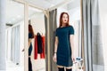 Young beautiful girl trying on new green dress in the fitting room in boutique Royalty Free Stock Photo