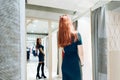 Young beautiful girl trying on new green dress in the fitting room in boutique Royalty Free Stock Photo