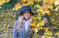 The young beautiful girl walks in the autumn park among yellow leaves in a coat on a sunny day Royalty Free Stock Photo