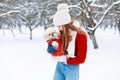 Young beautiful girl in a warm winter clothes plays with a puppy Royalty Free Stock Photo