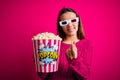 Young beautiful girl watching movie using 3d glasses eating box with popcorns doing money gesture with hands, asking for salary Royalty Free Stock Photo