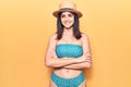 Young beautiful girl wearing bikini and summer hat happy face smiling with crossed arms looking at the camera Royalty Free Stock Photo