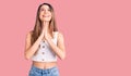 Young beautiful girl wearing casual sleeveless t shirt begging and praying with hands together with hope expression on face very Royalty Free Stock Photo