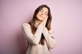 Young beautiful girl wearing casual turtleneck sweater standing over isolated pink background sleeping tired dreaming and posing Royalty Free Stock Photo