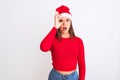 Young beautiful girl wearing Christmas Santa hat standing over isolated white background doing ok gesture shocked with surprised Royalty Free Stock Photo