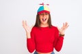 Young beautiful girl wearing fanny cap with propeller standing over isolated white background celebrating mad and crazy for