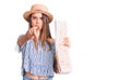 Young beautiful girl wearing hat holding city map pointing with finger to the camera and to you, confident gesture looking serious Royalty Free Stock Photo