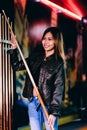 Young beautiful girl wearing leather jacket in a billiard club, with cue stick preparing for the game Royalty Free Stock Photo