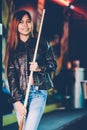 Young beautiful girl wearing leather jacket in a billiard club, with cue stick preparing for the game Royalty Free Stock Photo