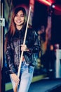 Young beautiful girl wearing leather jacket in a billiard club, with cue stick preparing for the game Royalty Free Stock Photo