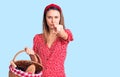 Young beautiful girl wearing picnic basket pointing with finger to the camera and to you, confident gesture looking serious Royalty Free Stock Photo