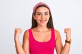 Young beautiful girl wearing pink casual t-shirt and diadem over isolated white background celebrating surprised and amazed for Royalty Free Stock Photo