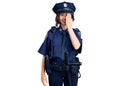 Young beautiful girl wearing police uniform covering one eye with hand, confident smile on face and surprise emotion Royalty Free Stock Photo