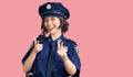 Young beautiful girl wearing police uniform pointing fingers to camera with happy and funny face Royalty Free Stock Photo