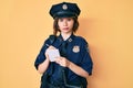 Young beautiful girl wearing police uniform writing traffic fine skeptic and nervous, frowning upset because of problem
