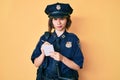 Young beautiful girl wearing police uniform writing traffic fine skeptic and nervous, frowning upset because of problem