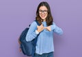 Young beautiful girl wearing student backpack smiling happy pointing with hand and finger