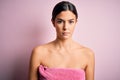 Young beautiful girl wearing towel shower after bath standing over isolated pink background with serious expression on face Royalty Free Stock Photo