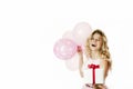 Young beautiful girl with a white gift with a red bow and balls in the hands rejoices on an isolated white background. Valentine