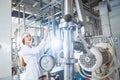 Young beautiful girl in white overalls at the plant for the production of sunflower and olive oil.