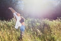 Young girl in white shirt raised her hands up in summer