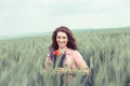 Young beautiful girl woman in a field holding flowers smiling, looking at you camera Royalty Free Stock Photo