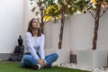 young beautiful girl woman meditating in house garden, budda statues Royalty Free Stock Photo