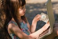 Young beautiful girl working with laptop and holding US Dollar bill as symbol of online payment and shopping. Summer vacation, Royalty Free Stock Photo