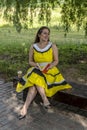 Young beautiful girl in a yellow dress with a book in the park. Reads, studies, rest Royalty Free Stock Photo