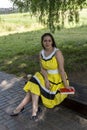 Young beautiful girl in a yellow dress with a book in the park. Reads, studies, rest Royalty Free Stock Photo