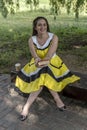 Young beautiful girl in a yellow dress with a book in the park. Reads, studies, rest Royalty Free Stock Photo