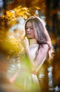 Young beautiful girl in a yellow dress in the woods. Portrait of romantic woman in fairy forest. Stunning fashionable teenager Royalty Free Stock Photo