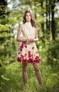 Young beautiful girl in a yellow dress in the woods. Portrait of romantic woman in fairy forest. Stunning fashionable teenager Royalty Free Stock Photo