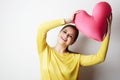 Young beautiful girl in yellow tshirt holding big plush red heart over empty white background.Lifestyle and Holiday Royalty Free Stock Photo