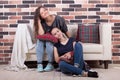 Young beautiful girlfriends sitting on the couch and smiling Royalty Free Stock Photo
