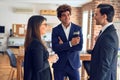 Young beautiful group of business workers smiling happy and confident, Standing with smile on face drinking coffee and speaking at Royalty Free Stock Photo