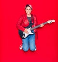 Young beautiful guitarist woman with pink short hair playing electric guitar smiling happy Royalty Free Stock Photo