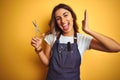 Young beautiful hairdresser woman holding scissors over yellow isolated background very happy and excited, winner expression Royalty Free Stock Photo