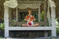 Young beautiful and happy American tourist woman practicing yoga and meditation sitting in lotus position at outdoors hut enjoying Royalty Free Stock Photo