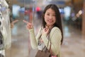 Young beautiful and happy Asian buying at shopping mall - young attractive and stylish Korean woman holding shopping bags at