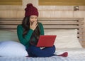 Young beautiful happy Asian Chinese girl in winter beamy relaxed on bed using laptop computer having fun enjoying online movie or Royalty Free Stock Photo