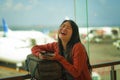 Young beautiful and happy Asian Chinese woman checking mobile phone holding passport at airport departure lounge carrying backpack Royalty Free Stock Photo