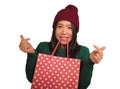 Young beautiful and happy Asian Chinese woman in cool winter hat holding shopping bag excited buying Christmas present smiling Royalty Free Stock Photo