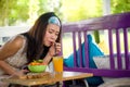 Young beautiful and happy Asian Chinese woman drinking orange juice eating healthy salad at organic food coffee shop outdoors enjo Royalty Free Stock Photo