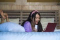 Young beautiful happy Asian Chinese woman using credit card internet banking on laptop computer at home in bed smiling shopping on Royalty Free Stock Photo