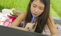 Young beautiful and happy Asian Chinese woman working outdoors with laptop computer networking green grass background cafe as digi Royalty Free Stock Photo