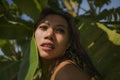 Young beautiful and happy Asian Indonesian woman in bikini posing between leaves of banana tree smiling natural isolated on exotic Royalty Free Stock Photo